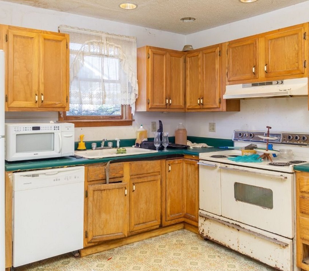 Kitchen before: honey oak cabinets, green counters and vinyl floor