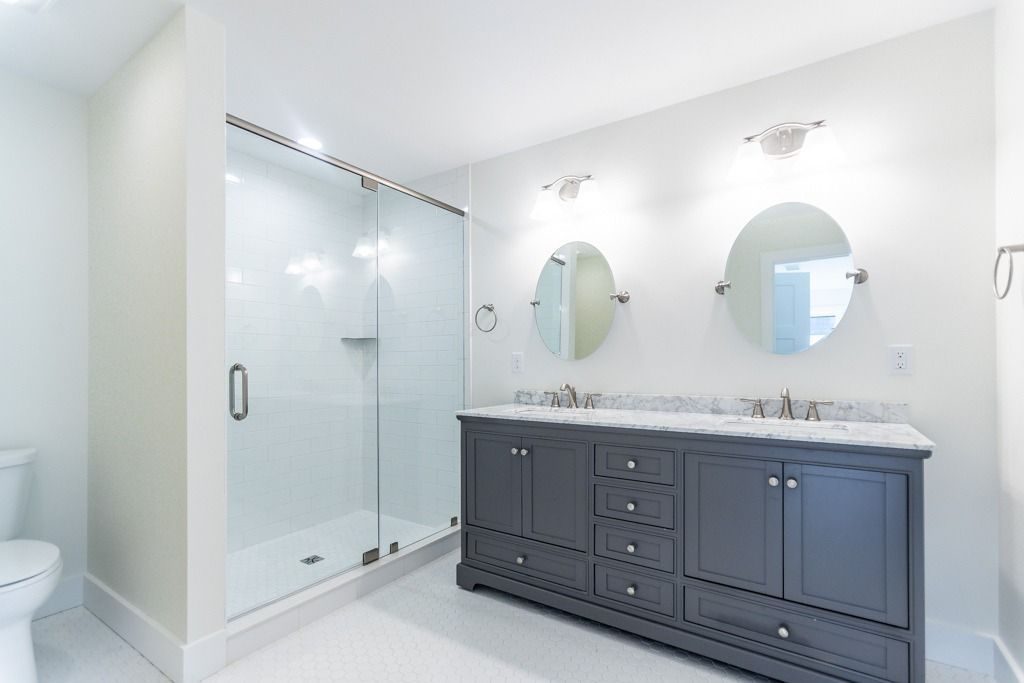 Bathroom with a glass shower and a navy double vanity