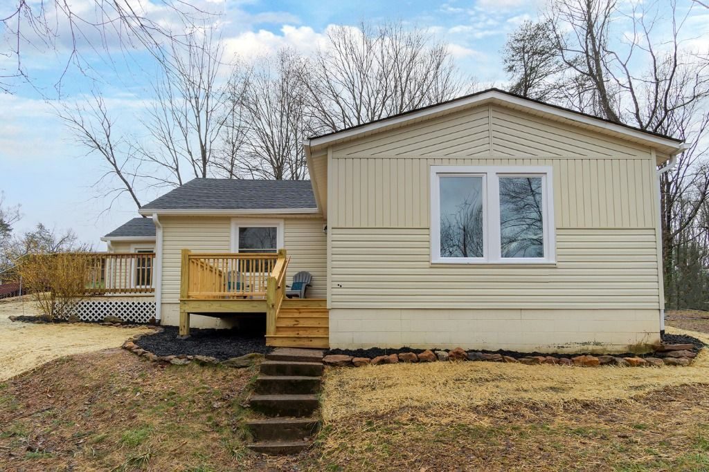 Cream-sided house with a new rear deck and steps
