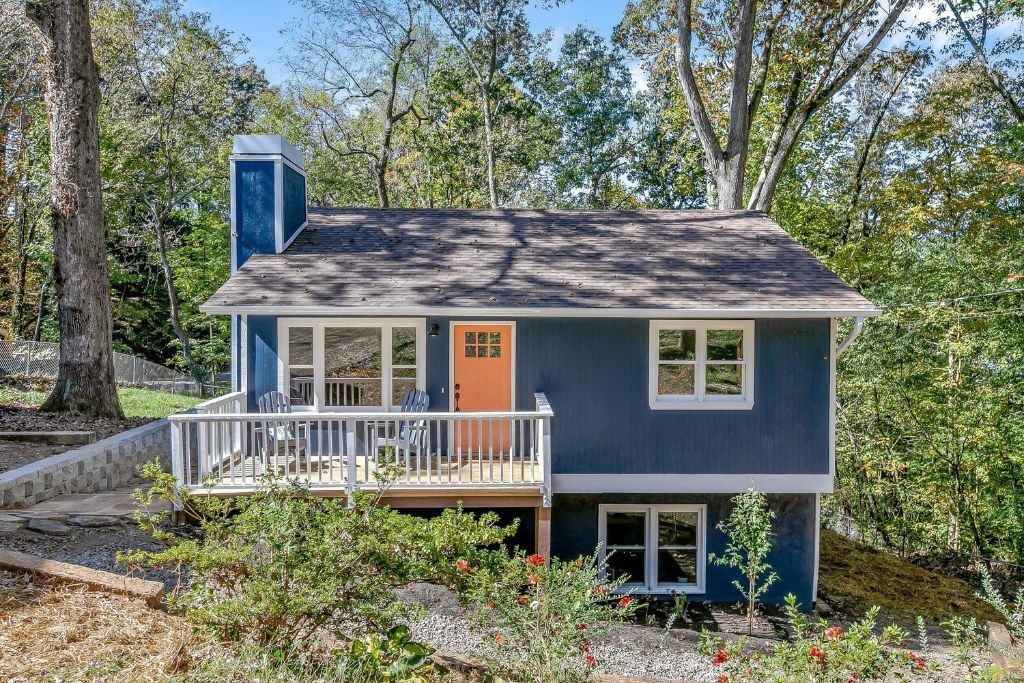 Navy two-story house with a white-railed rear deck