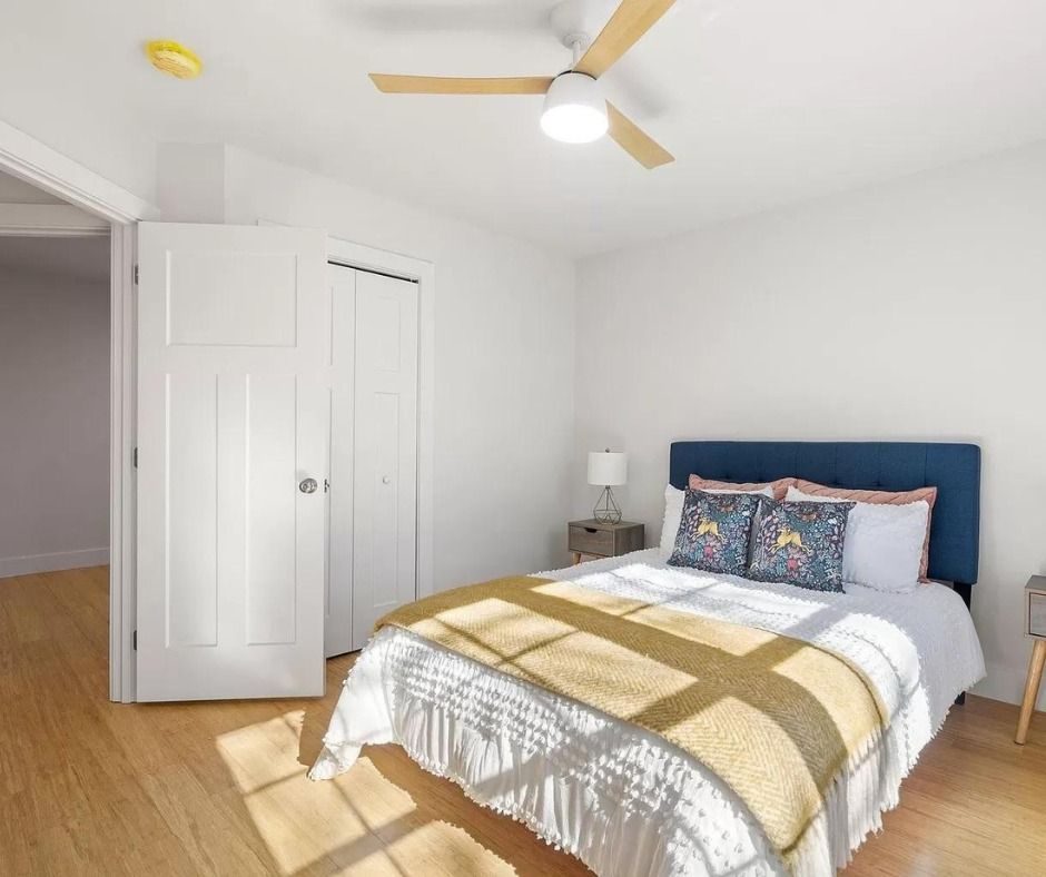 Bedroom with a ceiling fan and a navy upholstered headboard