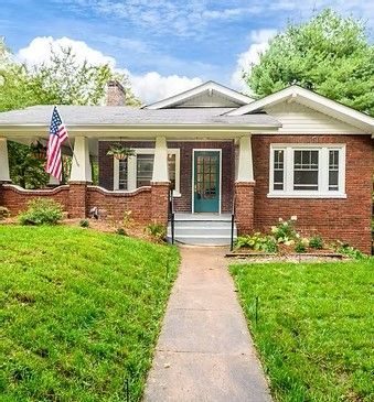 Brick craftsman bungalow with a teal door and a front walk