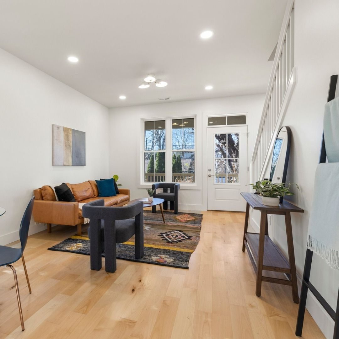 Bright living room with a cognac sofa, patterned rug and glass door