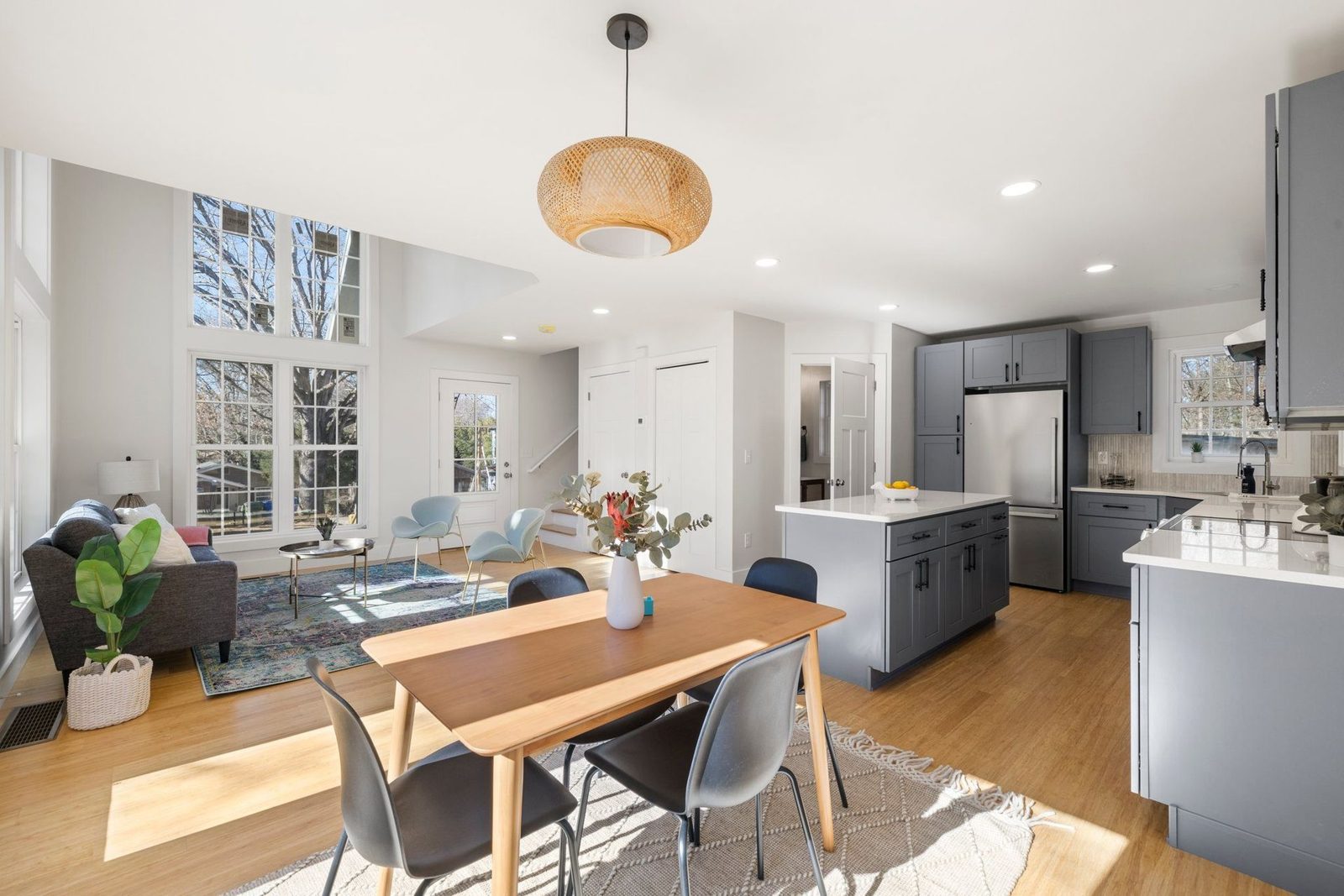 Open living, dining and kitchen area with light wood floors